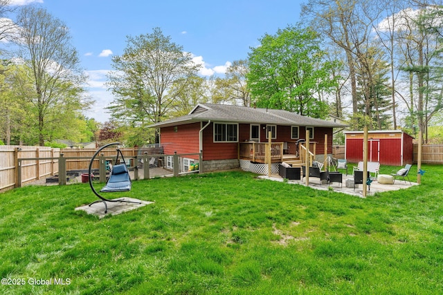 rear view of house with a patio area, a deck, an outbuilding, a storage unit, and an outdoor hangout area