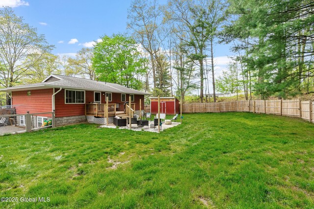 view of yard with a storage unit, a wooden deck, and an outdoor structure