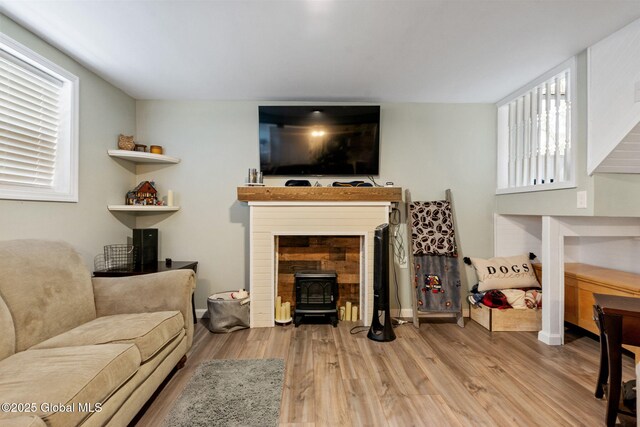 living area with wood finished floors and a wood stove