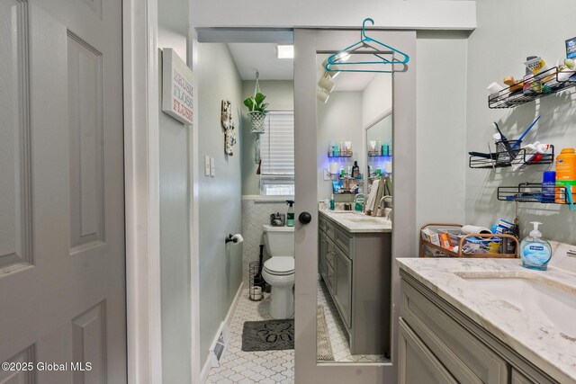 bathroom with vanity, toilet, and tile patterned floors