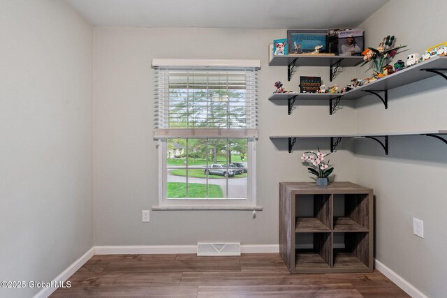 doorway to outside featuring healthy amount of natural light, wood finished floors, and baseboards