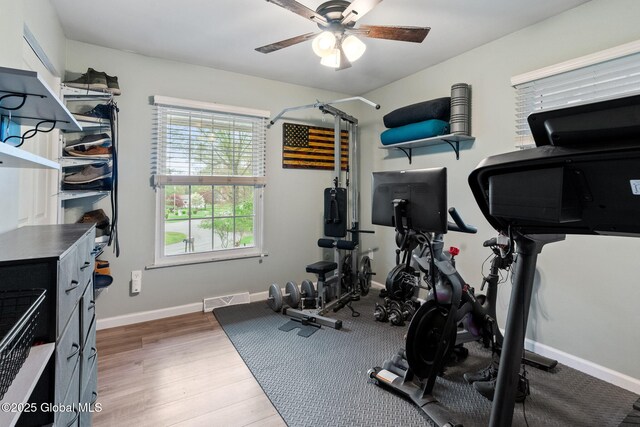 workout area with ceiling fan, wood finished floors, and baseboards