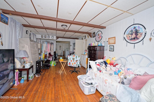 living room with a drop ceiling and wood-type flooring