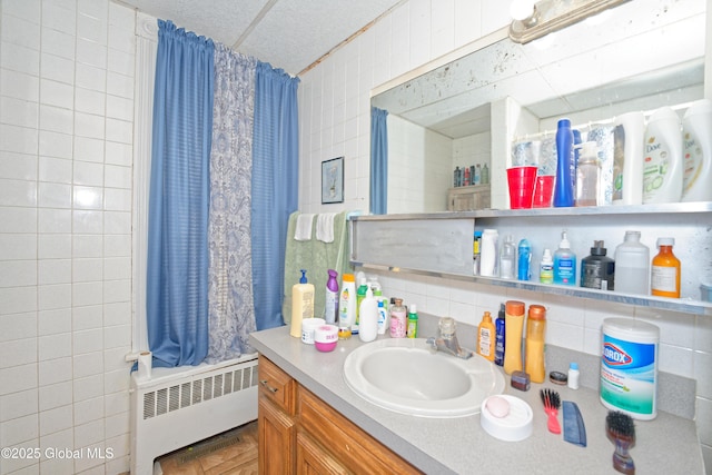 full bath with vanity and radiator heating unit