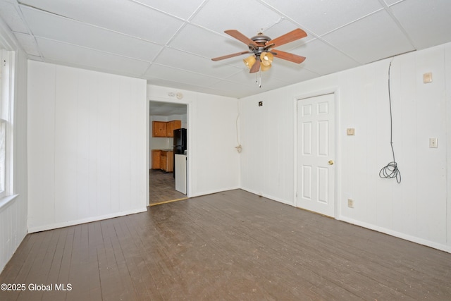 empty room featuring ceiling fan, baseboards, hardwood / wood-style floors, and a paneled ceiling