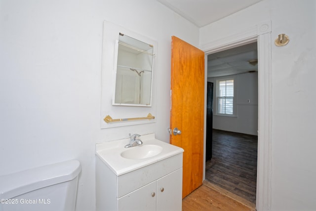 bathroom featuring toilet, vanity, and wood finished floors