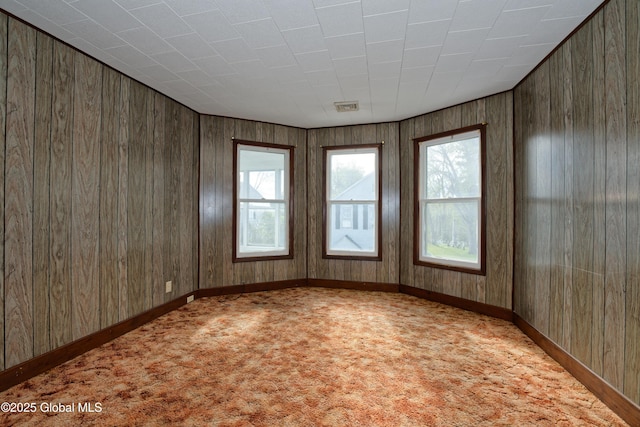 spare room with light carpet, a healthy amount of sunlight, and visible vents