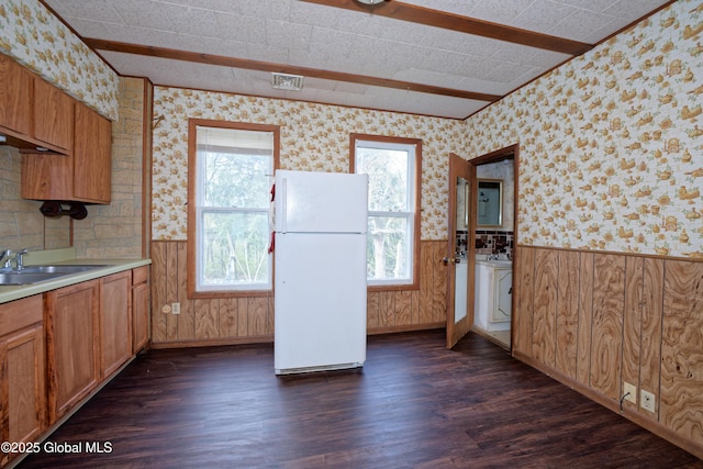 kitchen featuring freestanding refrigerator, wallpapered walls, dark wood-style flooring, and a sink
