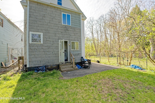 back of property featuring a yard, entry steps, and fence