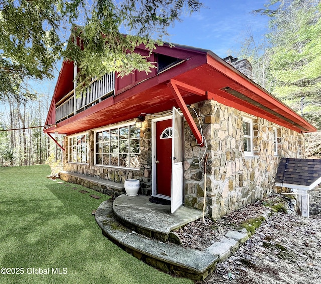 155 Bowen Hill Rd, Thurman, NY 12885 - view of front of house with stone siding, a chimney, a front yard, and a balcony