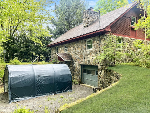 155 Bowen Hill Rd, Thurman, NY 12885 - view of side of home with stone siding, a chimney, an attached garage, and roof with shingles