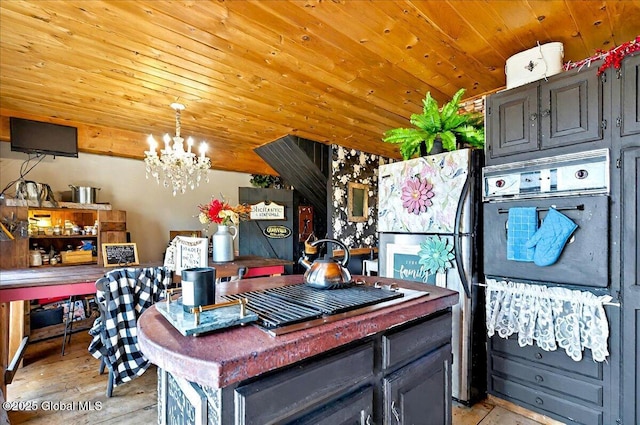 kitchen with freestanding refrigerator, wooden ceiling, an inviting chandelier, light wood finished floors, and hanging light fixtures