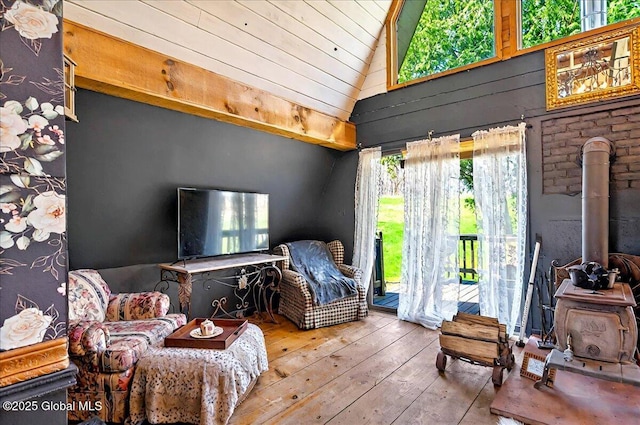 sitting room with a wood stove, hardwood / wood-style floors, wooden ceiling, and vaulted ceiling
