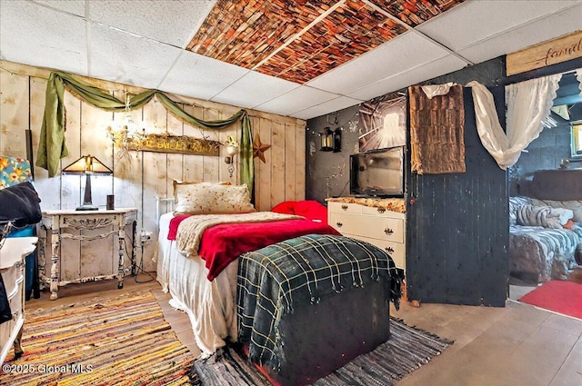 bedroom featuring wooden walls