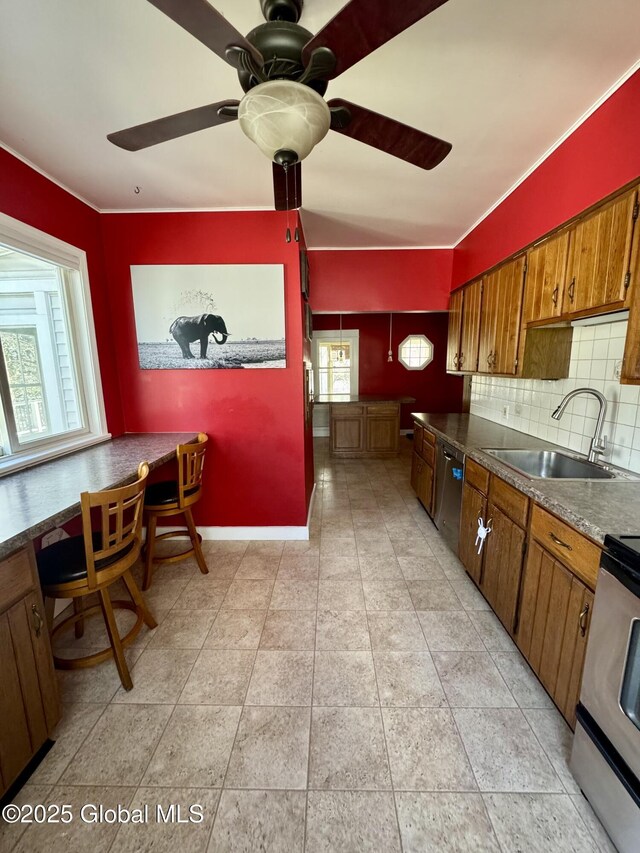 47 Washington Rd, Scotia, NY 12302 - kitchen featuring a ceiling fan, a sink, brown cabinetry, decorative backsplash, and stainless steel appliances