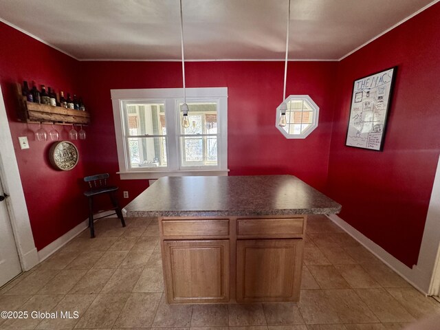 47 Washington Rd, Scotia, NY 12302 - kitchen featuring dark countertops, ornamental molding, light tile patterned flooring, a center island, and baseboards