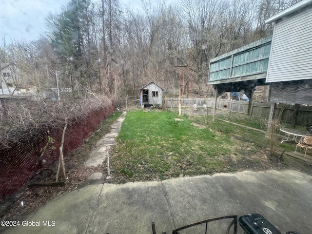 view of yard with a storage shed, an outbuilding, and fence