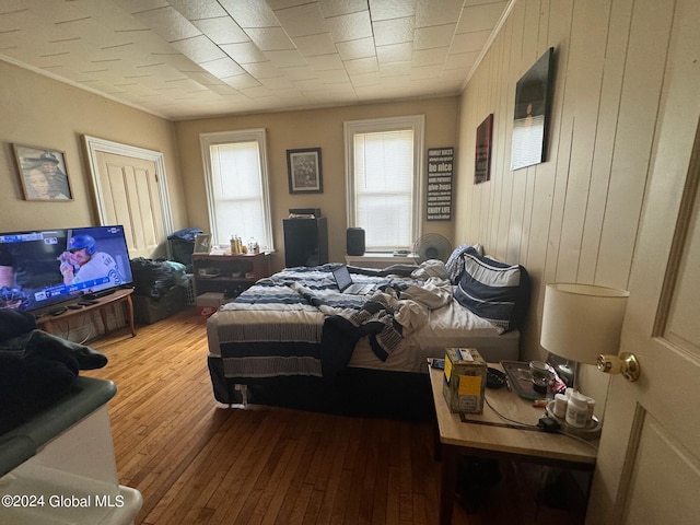 bedroom featuring wooden walls and hardwood / wood-style flooring