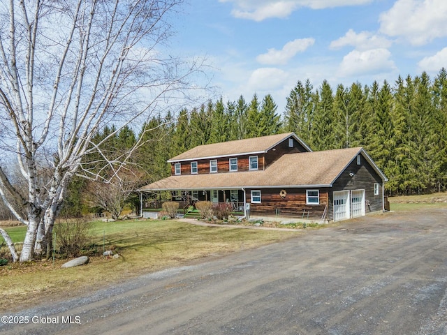 view of front facade with dirt driveway, a porch, and a front yard