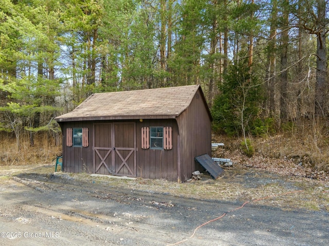 view of shed with a wooded view