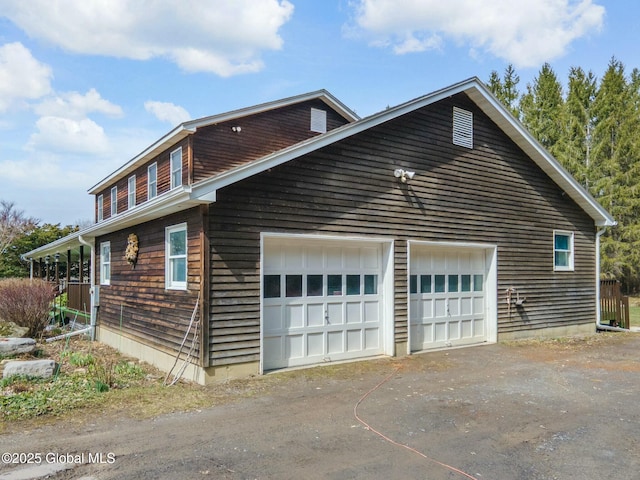 view of side of home with a garage and aphalt driveway