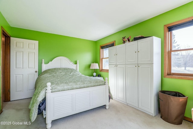 bedroom with multiple windows and light carpet