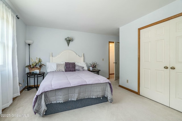 bedroom with light carpet, a closet, and baseboards