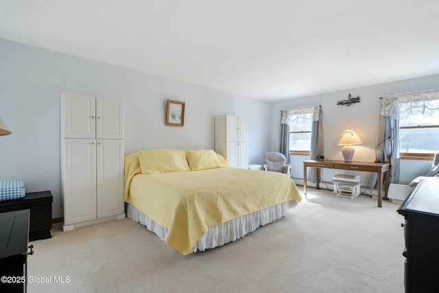 bedroom with light colored carpet and multiple windows