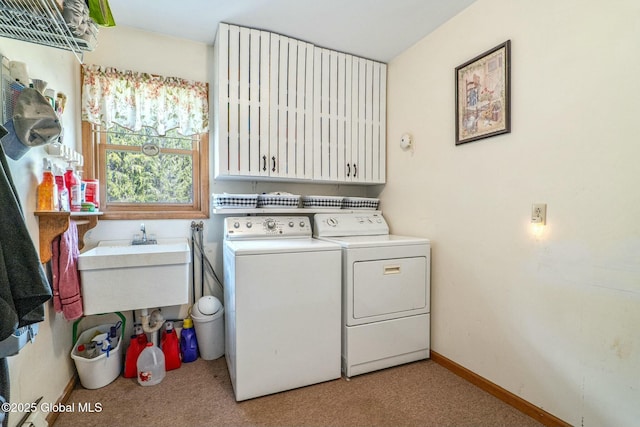 laundry room with washing machine and dryer, carpet floors, cabinet space, and baseboards