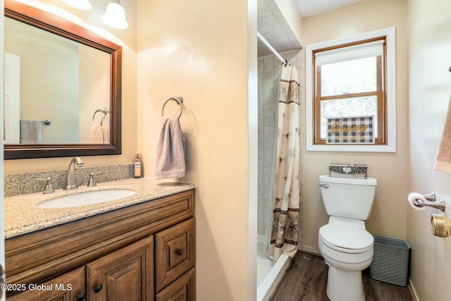 full bath with curtained shower, wood finished floors, toilet, vanity, and baseboards