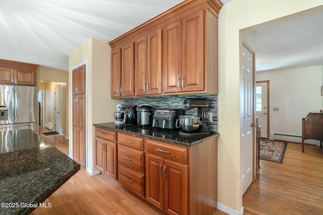 bar featuring a baseboard radiator, stainless steel refrigerator with ice dispenser, tasteful backsplash, and light wood finished floors