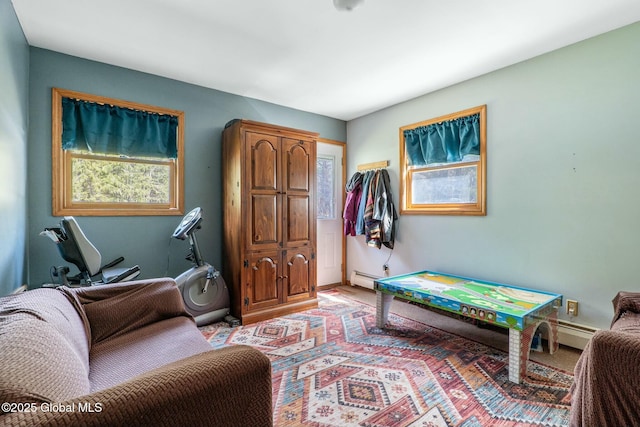game room with a baseboard radiator, light carpet, and baseboards