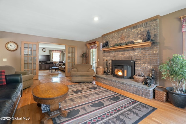 living area featuring french doors, wood finished floors, and a fireplace