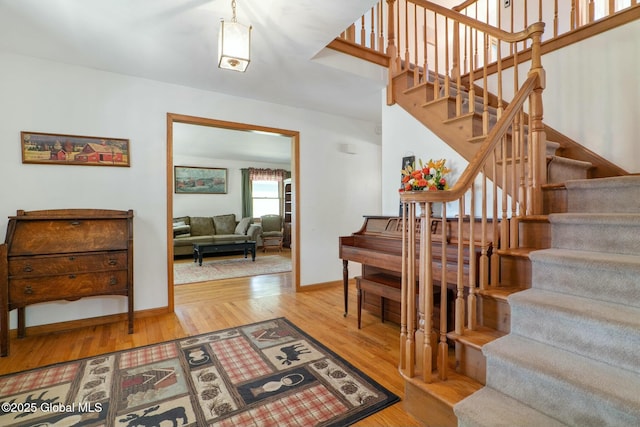 stairs with wood finished floors and baseboards