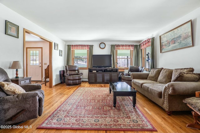 living room featuring a baseboard heating unit and light wood-style flooring