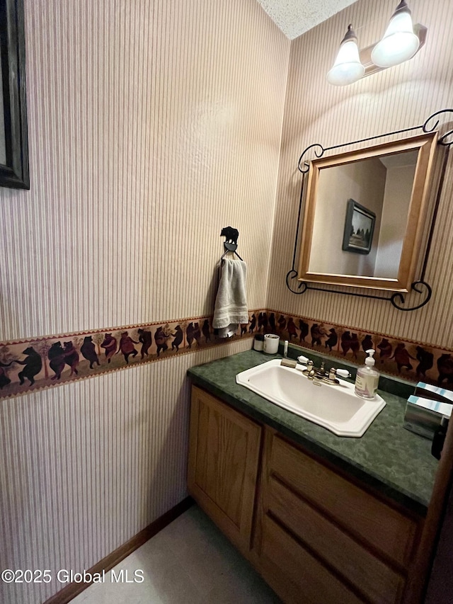 bathroom featuring wallpapered walls and vanity