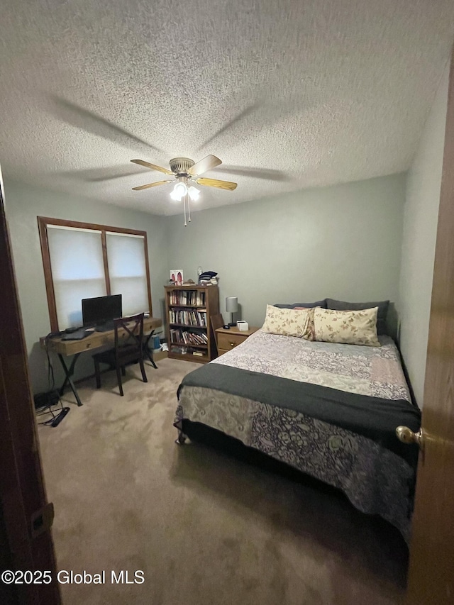 carpeted bedroom featuring a textured ceiling and ceiling fan