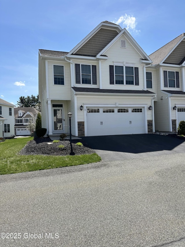 view of property with driveway, stone siding, and a garage