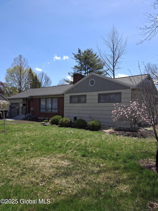 ranch-style house with an attached garage, a chimney, and a front yard