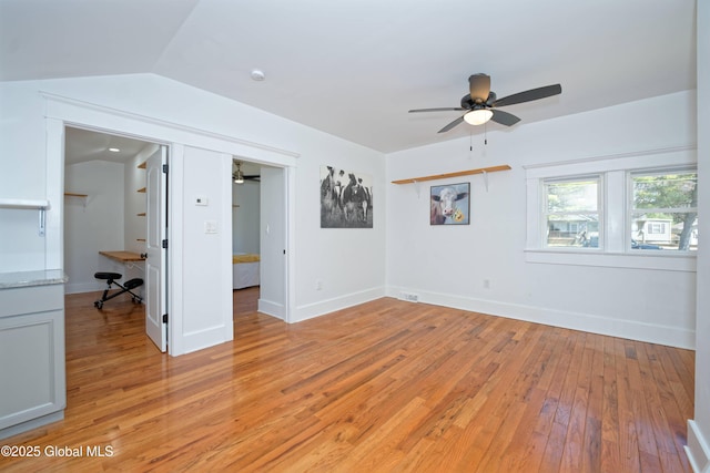 unfurnished room featuring ceiling fan, baseboards, lofted ceiling, and light wood-style floors