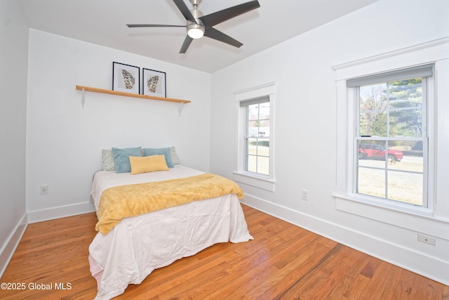 bedroom featuring baseboards, light wood-style floors, and ceiling fan