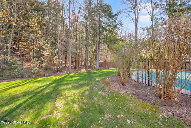 view of yard with a fenced in pool and fence