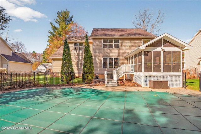 rear view of property with fence, a fenced in pool, and a sunroom