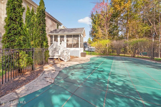 view of swimming pool featuring a fenced in pool, fence, a sunroom, and a patio area