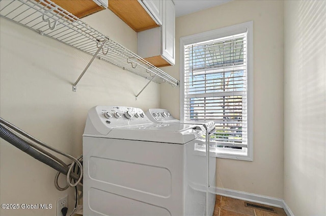 washroom with visible vents, baseboards, plenty of natural light, and washing machine and clothes dryer