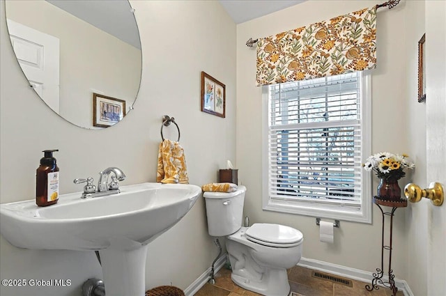bathroom featuring a sink, toilet, tile patterned floors, baseboards, and visible vents