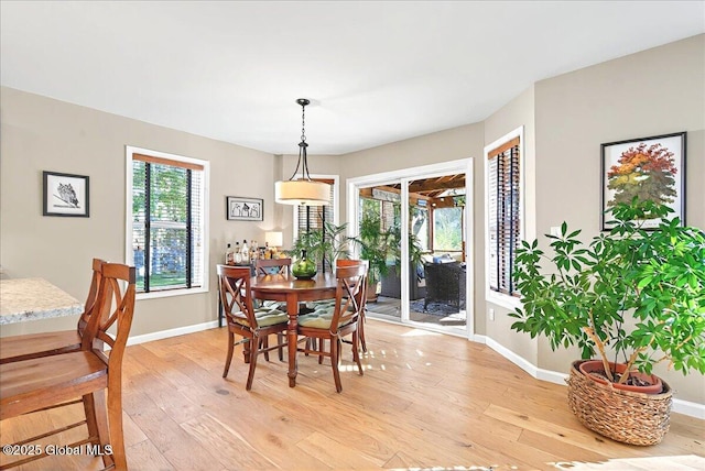 dining area with baseboards and light wood-style flooring