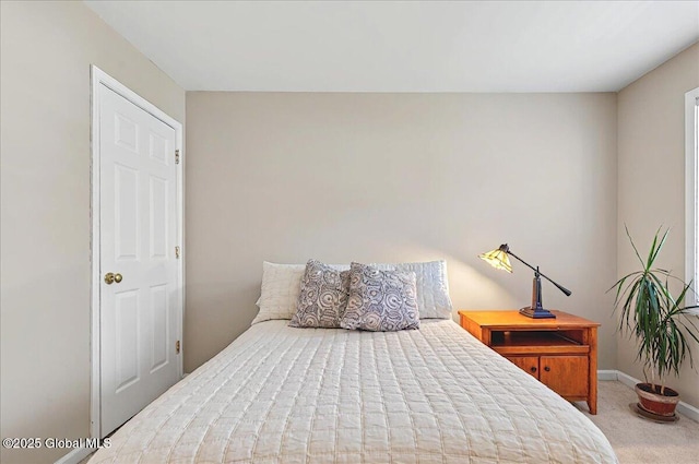 bedroom with baseboards and carpet