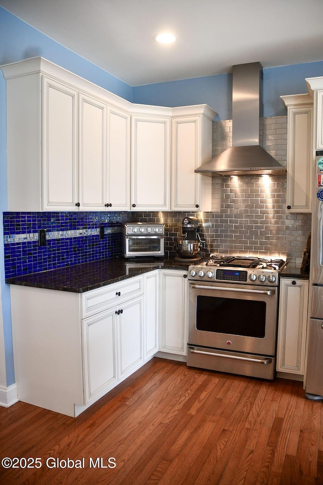 20 Fort Vaux Ln, Colonie, NY 12189 - kitchen featuring appliances with stainless steel finishes, wall chimney range hood, wood finished floors, decorative backsplash, and recessed lighting