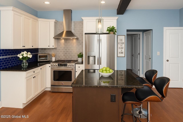 20 Fort Vaux Ln, Colonie, NY 12189 - kitchen with appliances with stainless steel finishes, wall chimney range hood, dark wood-style flooring, decorative backsplash, and a kitchen breakfast bar